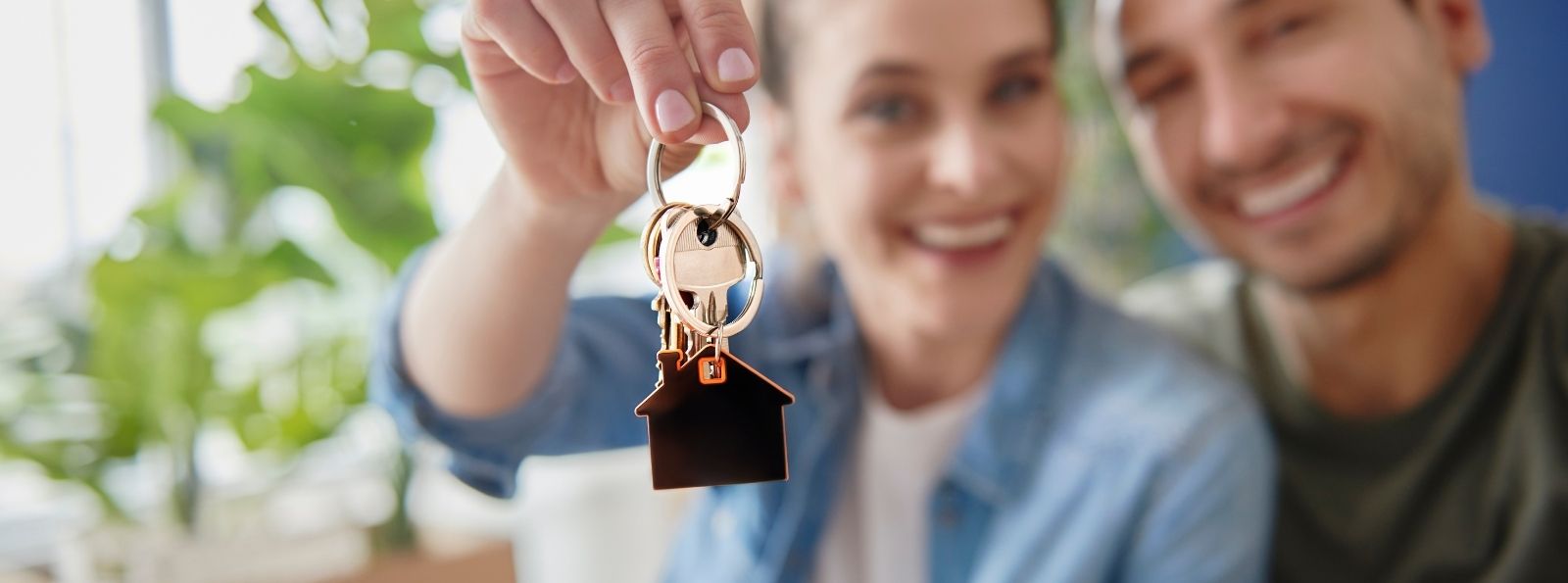 A couple holding up keys to their new house